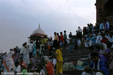 Worshitters resting on the stone steps of Jama Masjid, Delhi, at dusk
