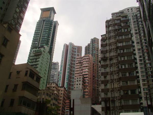 Crowded residential towers under grey sky, concrete facades and balconies