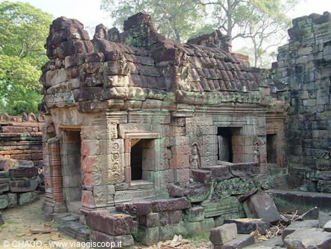 Ancient moss-covered stone temple with carved reliefs among green trees