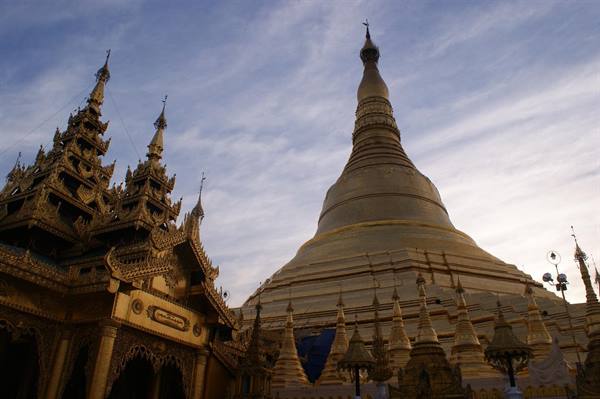 The golden Shwedagon Pagoda in Yangon glows under evening clouds