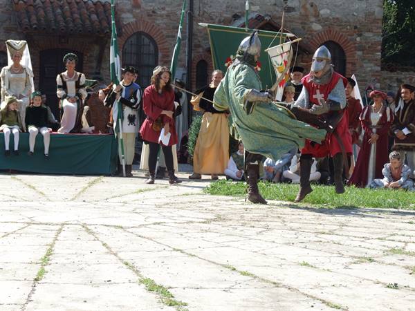 Armored knights dueling in medieval reenactment before costumed crowd in Soncino
