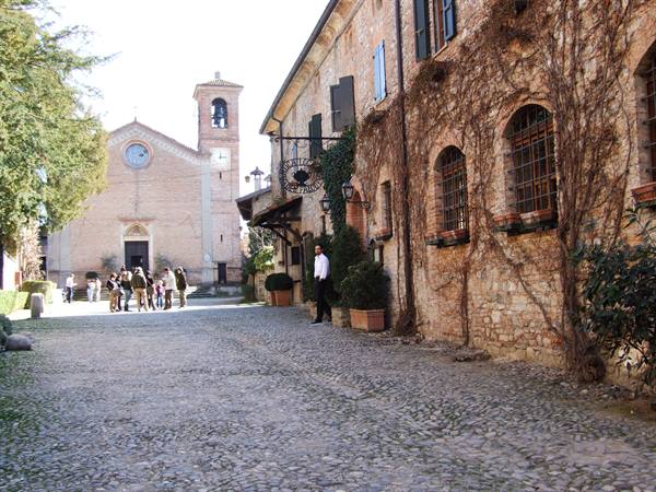 Cobblestone square with brick church and ivy-covered stone houses