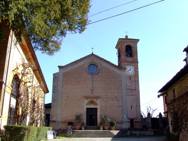 Brick church with rose window and clock bell tower under blue sky