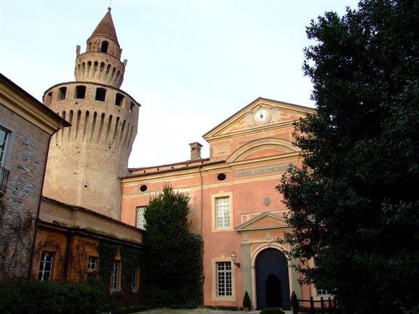 Brick tower of Scandiano fortress beside the pink façade