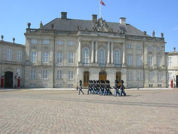 Royal guards marching in front of Amalienborg palace in Copenhagen, blue sky