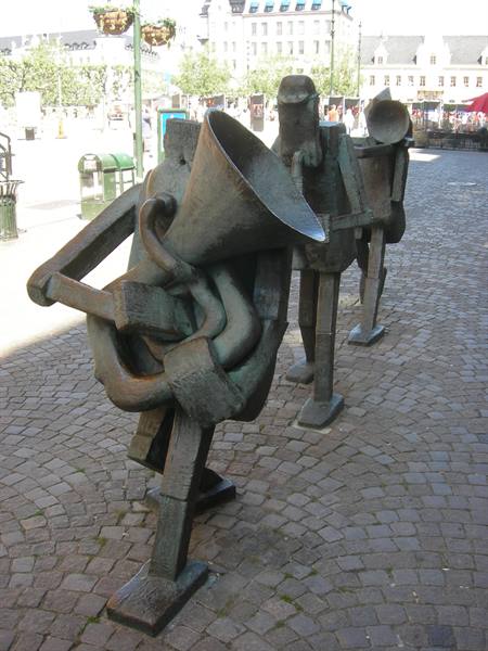 Bronze sculptures of musicians with instruments on a cobblestone square