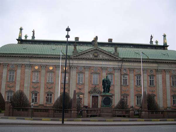 Bronze statue before the brick facade of Riddarhuset in Stockholm