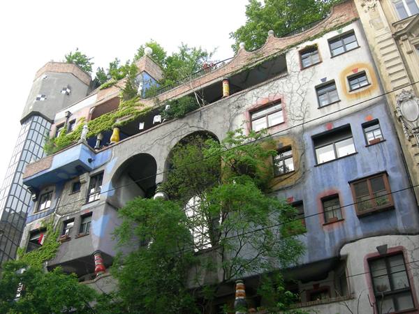Colorful Hundertwasserhaus facade in Vienna with trees and arches