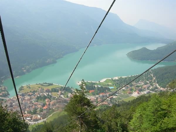 Cableway cables over turquoise Lake Molveno, village and mountains