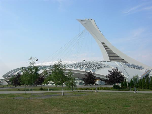 Montreal Olympic Stadium, tilted concrete tower and white roof among trees