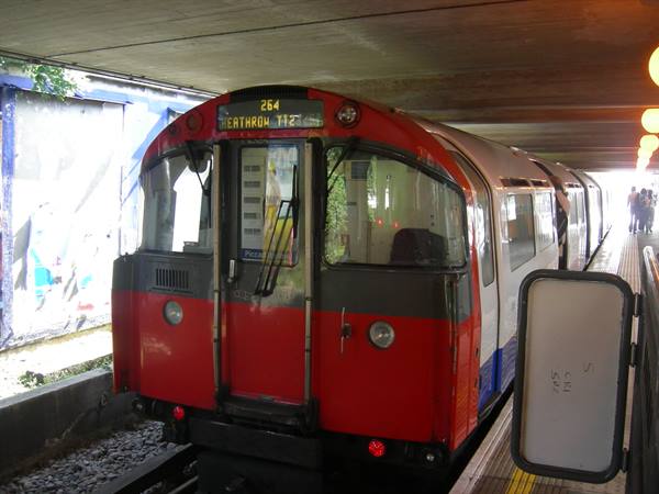 London Underground train bound for Heathrow under a concrete bridge