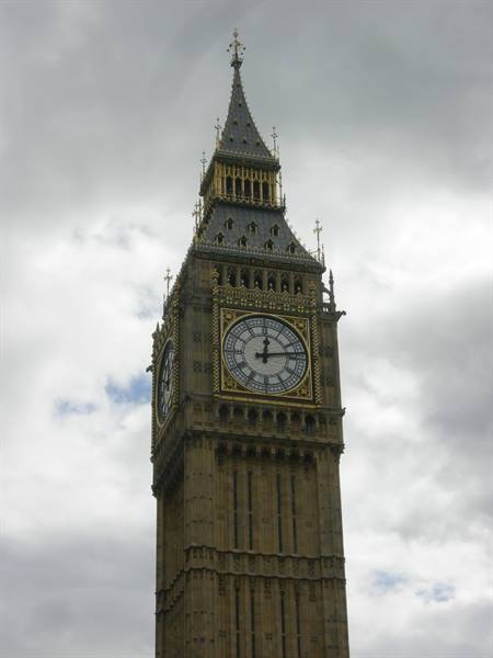 Big Ben clock tower in London, golden stone against cloudy sky