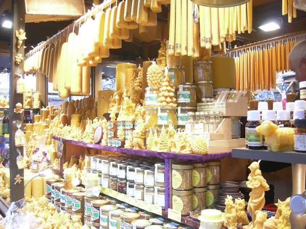 Market stall with hanging beeswax candles and jars of honey