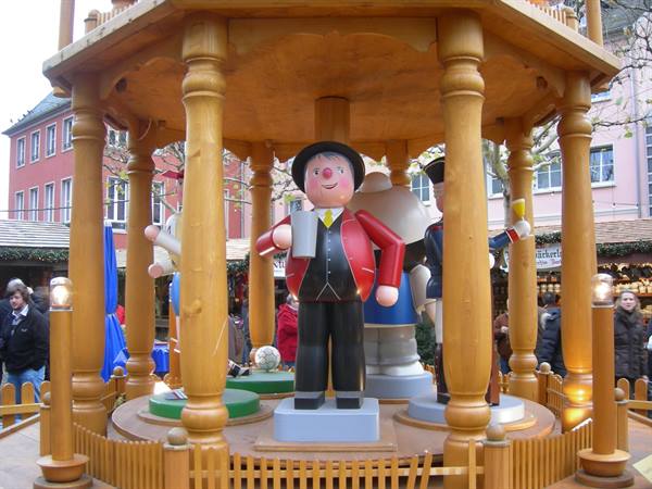 Wooden figurine holding a beer mug in the spinning Christmas market pavilion