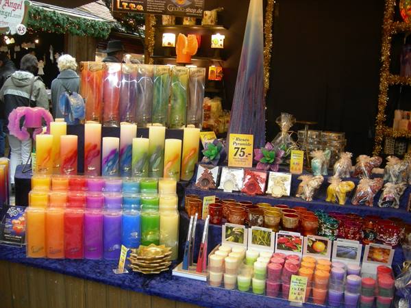 Christmas market stall displaying colorful candles and candle holders