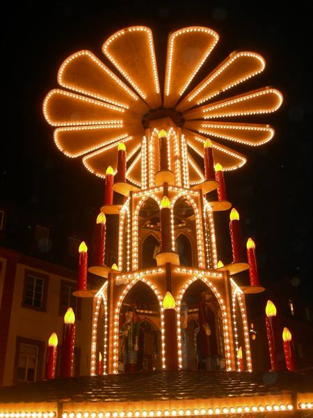 Illuminated wooden Christmas pyramid with candle figures at a German Christmas market