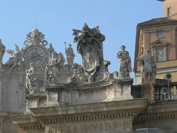 Marble statues and papal coat of arms on St. Peter's Square colonnade