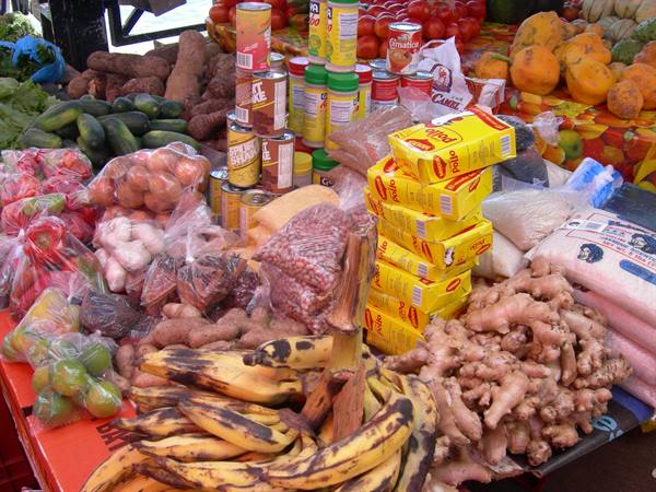 Market stalls with bananas, ginger, onions and boxes of pasta