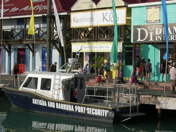 Antigua and Barbuda port security boat moored in front of colorful shops at St John's
