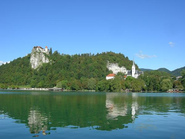 Bled Castle on the cliff and church tower above the green lake
