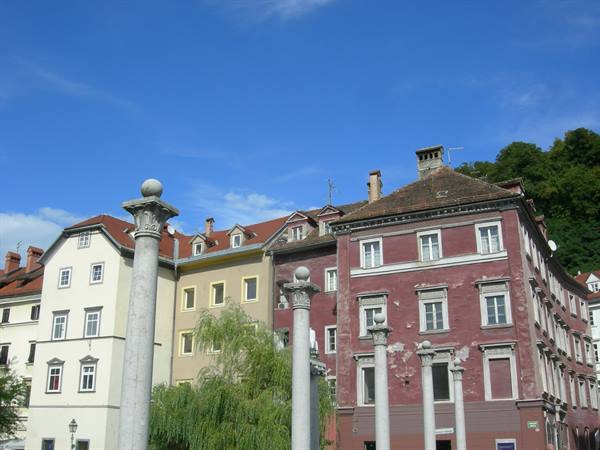 Stone columns in front of colorful houses in Ljubljana