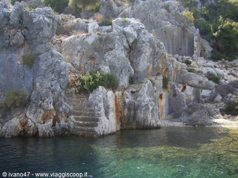 Ancient rock-cut steps descend into the green water of Kekova