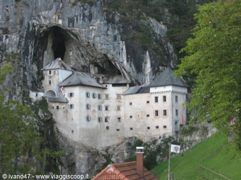 Predjama Castle built into the rocky cliff face above the trees