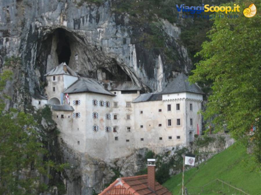 Predjama Castle built into the rocky cliff face above the trees