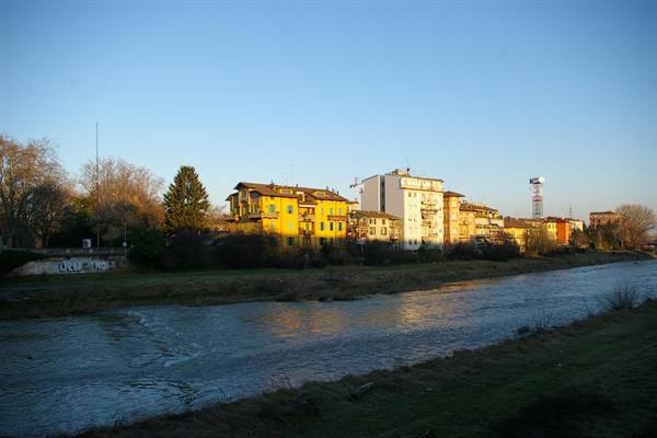 River flowing past colorful buildings on the bank under blue sky