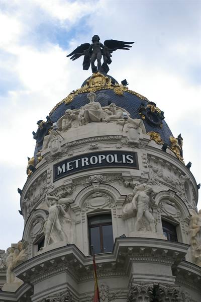 Metropolis Building in Madrid, golden dome with winged statue against the sky