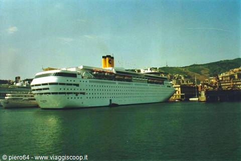White cruise ship with yellow funnel docked at Genoa harbor