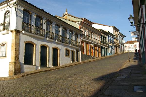 Colonial houses with wrought-iron balconies on a sloped cobblestone street, Ouro Preto