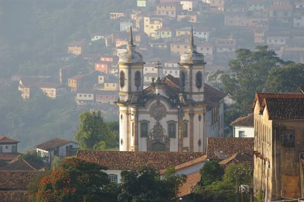 White baroque church with twin towers above Ouro Preto rooftops
