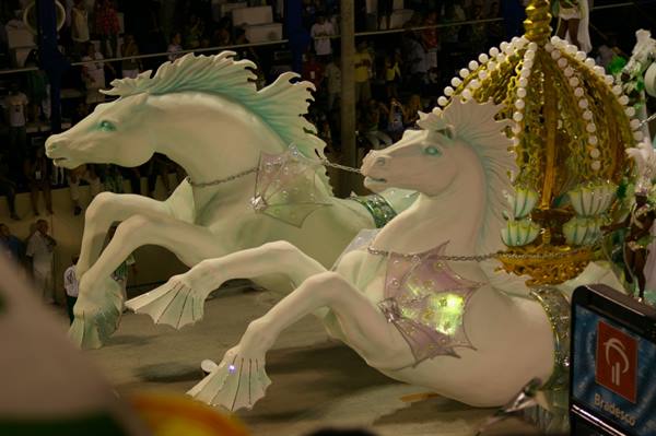 White papier-mâché horses pull a golden carnival float