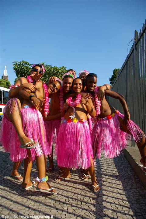 Group of friends wearing pink hula skirts and flower leis at carnival