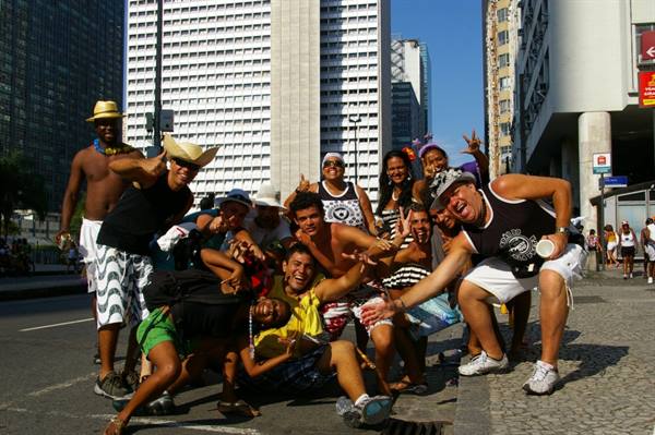 Street carnival: cheerful crowd in straw hats poses among downtown skyscrapers