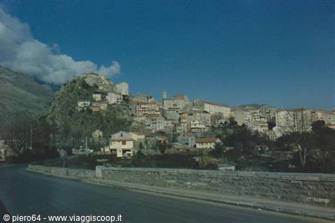 Stone houses village on rocky hill, blue sky with clouds