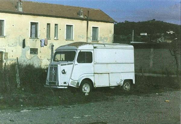 Old rusty white Citroën van beside a yellow rural house