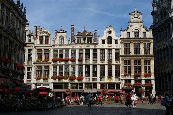 Ornate gilded guildhalls with flower boxes and red cafe umbrellas on Brussels' Grand-Place