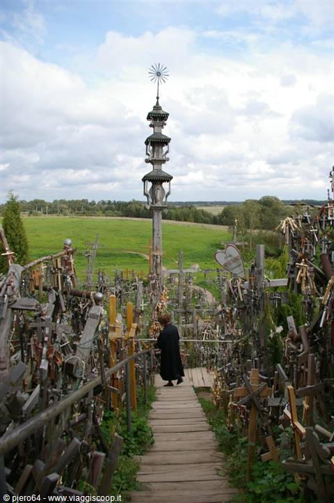 Thousands of wooden and metal crosses at the Hill of Crosses, woman walking up the path