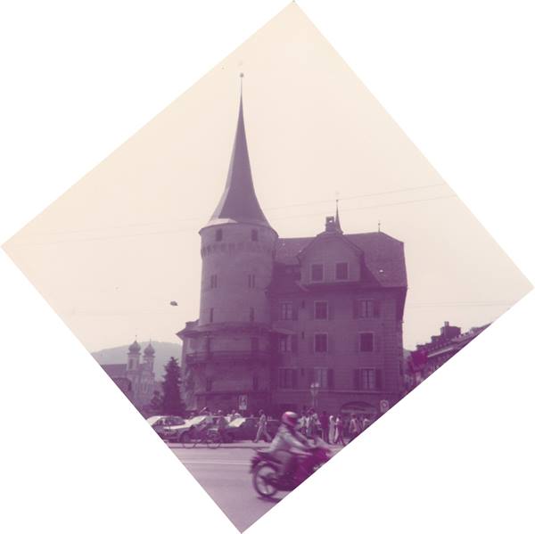 Motorbike rides past the medieval stone tower in Lucerne