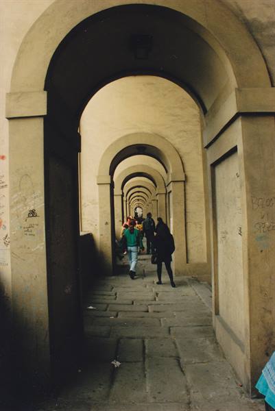 Tourists walk through the arched gallery of the Vasari Corridor in Florence