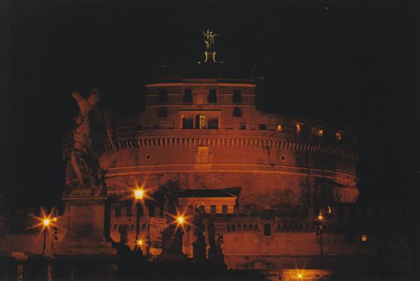 Castel Sant'Angelo at night, statues and glowing street lamps along the bridge