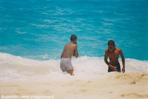 Two boys playing in the waves on a sandy beach
