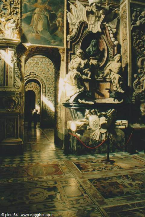 Marble statues and inlaid floor inside a baroque church, side light
