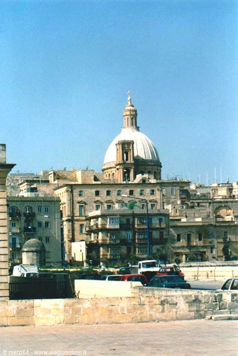 Carmelite church dome rising over limestone buildings in Valletta
