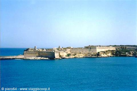 Limestone fortress walls along the Malta coast, blue sea