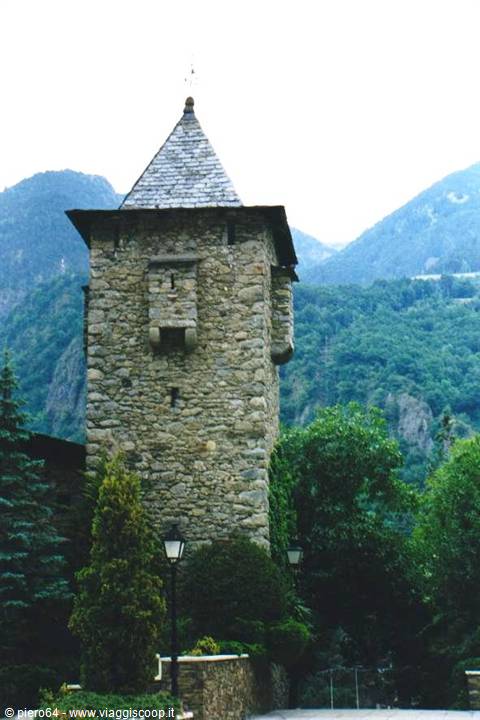 Stone tower with slate roof among green mountains and trees, Andorra