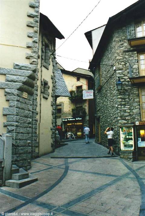 Alley with stone houses and people photographing in Ordino