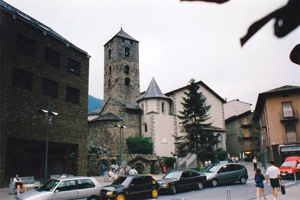 Sant Esteve church in Andorra la Vella, stone Romanesque bell tower, cars in street